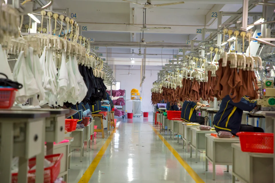 Garments on overhead hangers along a sewing production line